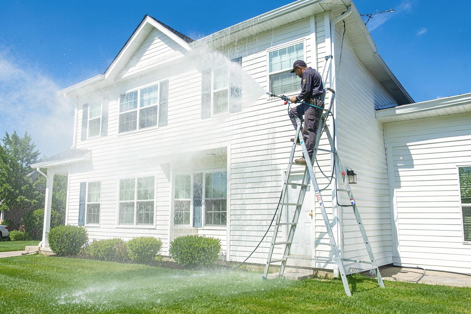 Pressure washing the siding of a home